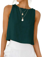 Dark green sleeveless crop top with layered necklaces, paired with white pants for modern women's fashion
